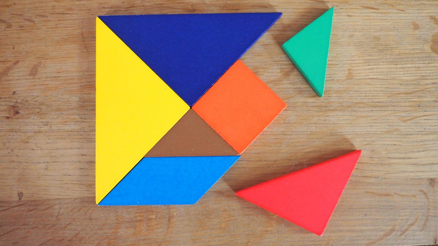 Bunte Tangram-Teile aus Holz auf einem Tisch